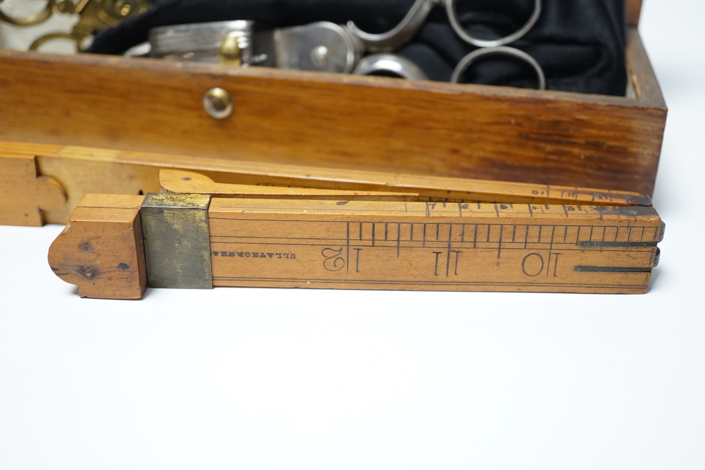 A glove box containing a boxwood foot-measure, two candle snuffers, a silver teaspoon etc